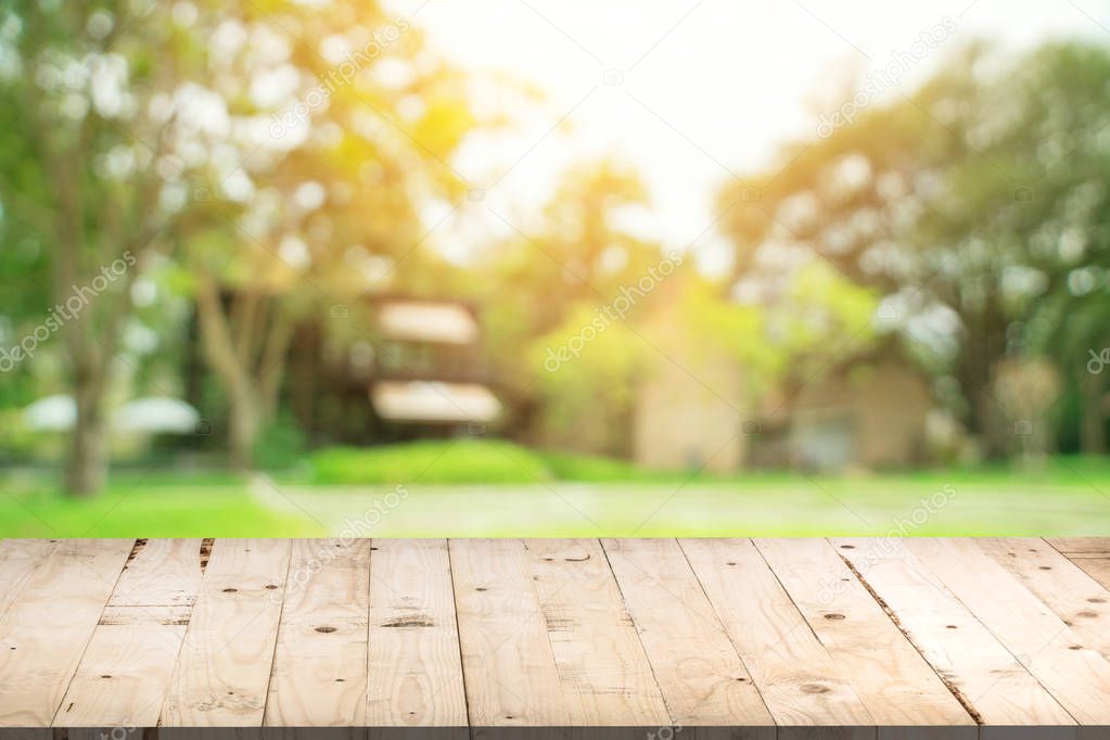 Empty wood table and defocused bokeh and blur background of gard