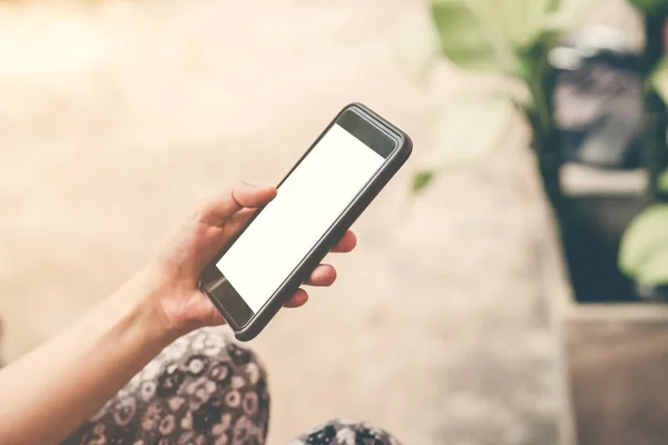 Chiudi la mano donna in possesso e utilizzando il telefono in giardino . — Foto Stock