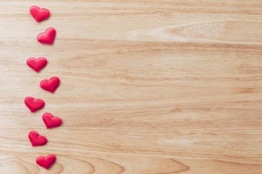 Tahta masa arkaplanındaki kırmızı kalbi kopyalama alanı ile üst görünüm.