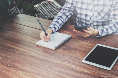 Kadın el yazısı ve ahşap masaya telefon kullanımı.