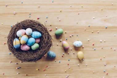 Ahşap arka planda Paskalya yumurtaları doğal ışık ile üstten görünüyor. Düzleştirme biçimi.