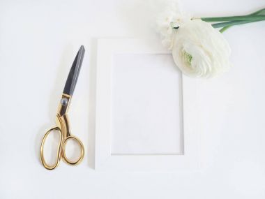 Stok fotoğraf tarz. Kadınsı ürün mockup düğün çiçeği, tipik ve Nergis çiçek, boş beyaz bir çerçeve ve beyaz zemin üzerine altın makas ile. Düz yatıyordu, en iyi görünümü.