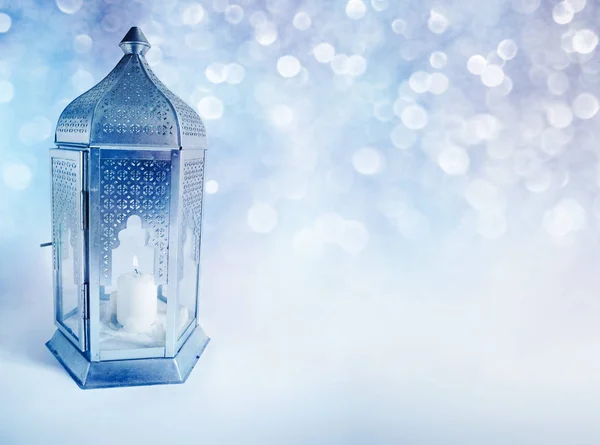 Prydnads arabiska lykta med brinnande ljus glödande nattetid. Gratulationskort, inbjudan för den muslimska gemenskapen heliga månaden Ramadan Kareem. Glittrande festliga blå bakgrunden med bokeh-lampor. — Stockfoto