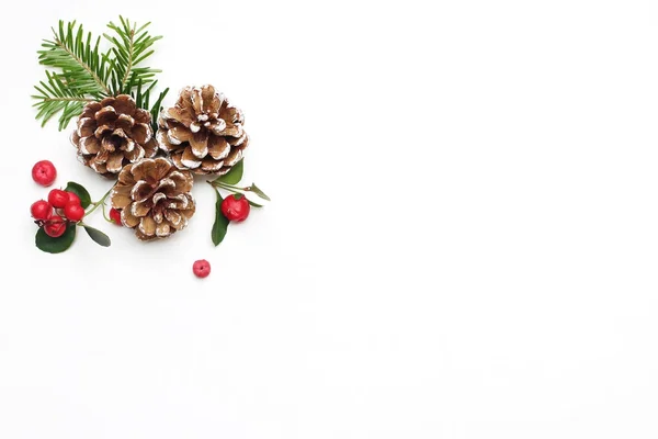 Boże Narodzenie, Świąteczna stylizowany obraz kompozycji kwiatowych. Szyszki, gałęzie drzewa jodły i jagody gaultheria czerwony na białym tle drewnianych. Widok płaski świeckich, najwyższej z puste miejsce. — Zdjęcie stockowe
