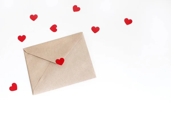 Valentin-nap, vagy esküvő makett jelenet papír boríték, piros szív konfetti elszigetelt fehér background. Stílusú a stock fotó, lakás feküdt, felülnézet. A szöveget a üres hely. — Stock Fotó
