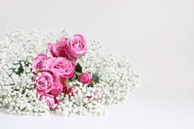 Düğün stok fotoğraf tarz. Beyaz masa arka plan üzerinde pembe Gül ve babys nefes Gypsophila çiçekler ile natürmort. Çiçek kompozisyon. Görüntü blog ya da sosyal medya için.