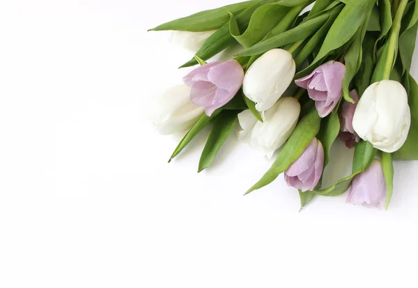 Våren stylad lager foto. Påsk-konceptet. Feminina stationära scen med blombukett vit och violett tulip på vitt bordsbakgrund. Tomt utrymme. Platt lekmanna, top view. — Stockfoto