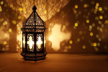 Yanma ile süs Arapça fener mum geceleri parlak ve ışıltılı altın bokeh ışıklar. Bayram tebrik kartı, Müslüman kutsal ay Ramazan Kareem için davet. Koyu arka plan.