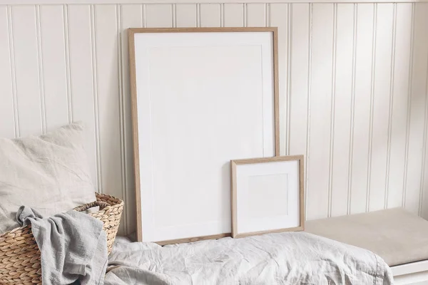 Porträt und quadratische, leere Holzrahmen-Attrappen mit Strohkorb und Leinentuch. weiße Wandverkleidung aus Perlmutt Hintergrund. skandinavisches Interieur, Wohndesign. Kunstkonzept. — Stockfoto