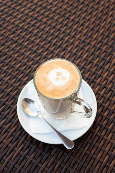 Xícara de café de arte de latte quente na mesa de madeira de vime . — Fotografia de Stock