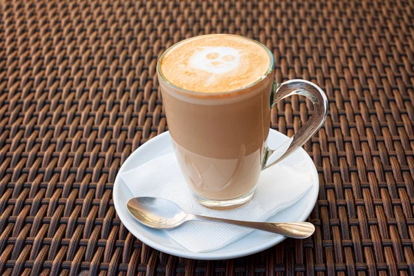 Kopje hete latte art koffie op rieten houten tafel. — Stockfoto