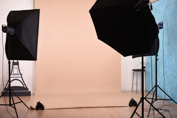 Studio foto kosong dengan peralatan pencahayaan dan latar belakang kertas siap untuk pemotretan . — Stok Foto