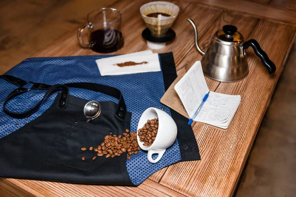 Barista Schürze auf dem Tisch im Café mit verschiedenen Sachen für alternative Kaffeezubereitung. Produktfotografie. Bereitstellungsdienstkonzept. — Stockfoto
