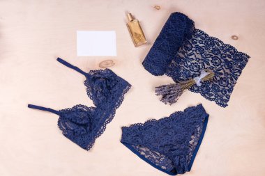 Alışveriş ve moda konsepti. Kozmetik ürünleri ve ahşap arka planda kadın aksesuarları olan göz kamaştırıcı, seksi dantel iç çamaşırları..