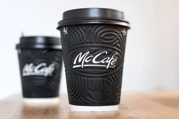 Kiev, ukraine: 06. November 2019: mcdonald 's coffee in black cups mccafe auf holztisch auf hellem hintergrund. — Stockfoto