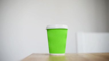 Yakın plan kadın kahve ya da çay alır, kağıt bardağa odaklanır. El yapımı kahve, kahvaltı için sıcak içecek, paket servis.