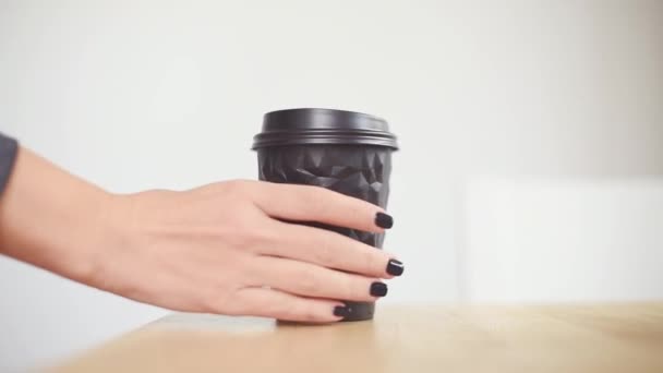 Primer plano femenino toma un café o té, se centran en la taza de papel. Taza de papel de mano de café, bebida caliente para el desayuno, servicio de comida para llevar — Vídeo de stock