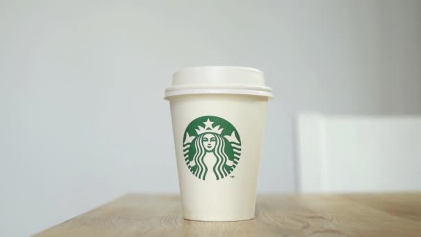 Kyjev, Ukrajina. Listopad 06, 2019: Detailní záběr fenka si bere kávu Starbucks, soustředí se na papírový šálek. Ruční braní papírový šálek kávy, donáška služby — Stock video