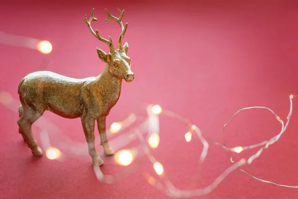 Rena de Natal com luzes de Natal e decorações. Bonito brinquedo de rena dourada, decoração de Santa ajudante, bugiganga de árvore de Natal. Conceito de Ano Novo . — Fotografia de Stock