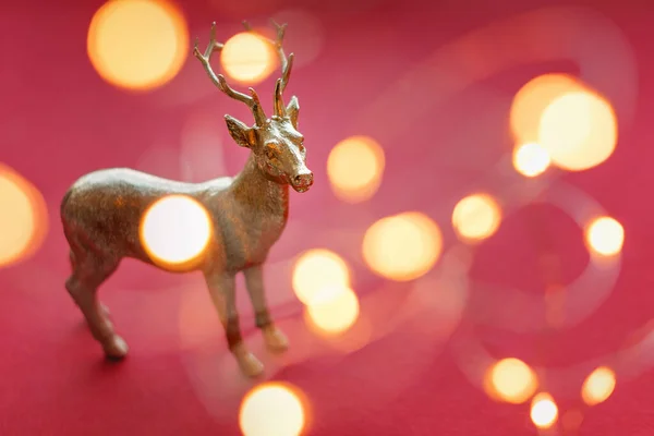 Rena de Natal com luzes de Natal e decorações. Bonito brinquedo de rena dourada, decoração de Santa ajudante, bugiganga de árvore de Natal. Conceito de Ano Novo . — Fotografia de Stock