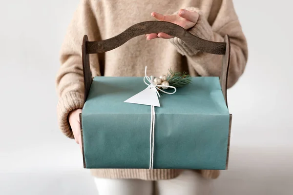 Donna irriconoscibile che regge il regalo di Natale in scatola blu con fiocco. Buone vacanze invernali. Regali per la celebrazione del Natale . — Foto Stock