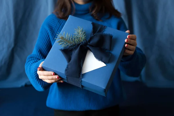 Mujer irreconocible sosteniendo regalo de Navidad en caja azul con lazo. Felices fiestas de invierno. Regalos para la celebración de Navidad . — Foto de Stock