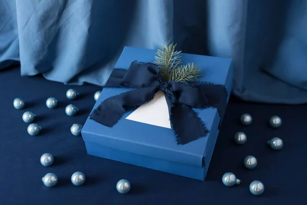 Presentes de Ano Novo, caixa azul no fundo azul com decoração de férias de inverno. Fundo de Natal com caixa de presente. Presentes para a celebração do Natal . — Fotografia de Stock