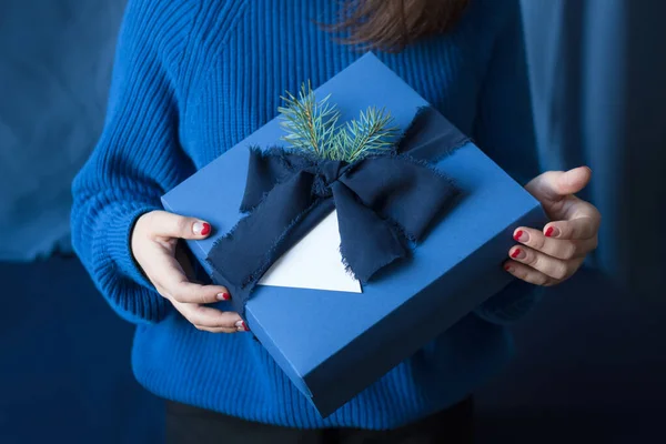 Mujer irreconocible sosteniendo regalo de Navidad en caja azul con lazo. Felices fiestas de invierno. Regalos para la celebración de Navidad . — Foto de Stock