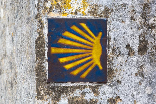 Gelbe Jakobsmuschel, touristisches Symbol des Camino de Santiago, der Richtung auf dem Camino Norte in Spanien zeigt. Unterzeichnung des Weges zum santiago de compostela auf dem Jakobsweg. — Stockfoto