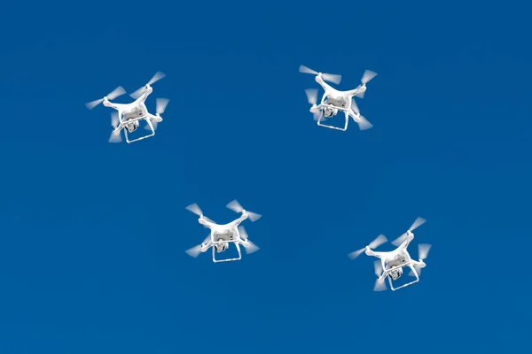 Mavi gökyüzünde düzinelerce dron akın ediyor. Şehrin üzerinde dijital kameralı Quadcopters dronları var. Aero çekimlerinde ve çekimlerinde yeni teknoloji. — Stok fotoğraf