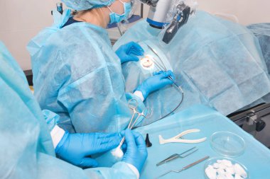 Hemşire ameliyat sırasında bir doktora alet veriyor. Hastane ameliyatı sırasında doktorların elleri. Kulak ameliyatı