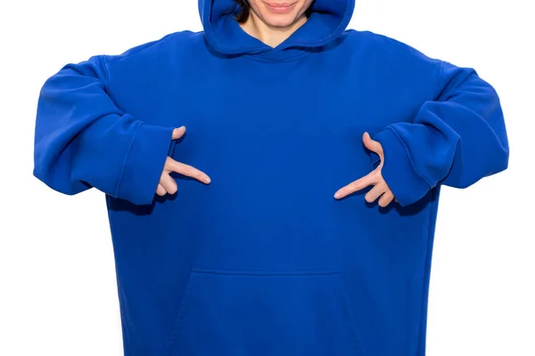 Young hipster girl wearing blue hoodie and pointing fingers with space for your logo or design. Woman pointing to chest with both hands, copy space for text. — 스톡 사진