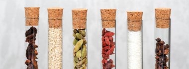 Cam şişelerdeki çeşitli baharatlar. Yemek, kakule, hindistan cevizi, karanfil, yıldız anason, goji üzümü için ev yapımı baharatlar..