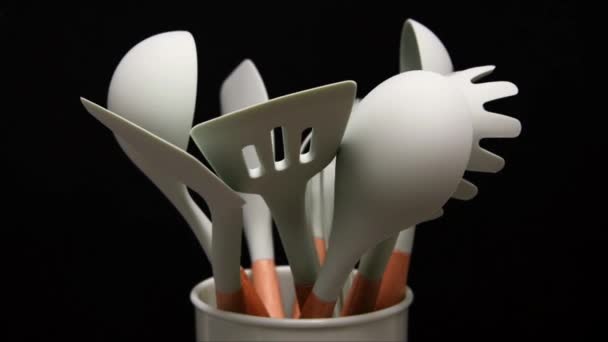 Rotation of silicone or rubber kitchen utensils on black background. Tools for cooking — Stock Video