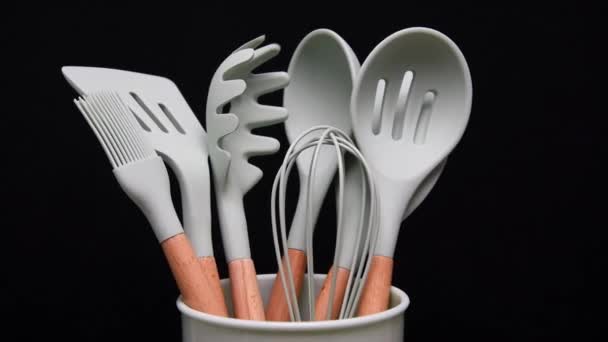 Rotation of silicone or rubber kitchen utensils on black background. Tools for cooking — Stock Video