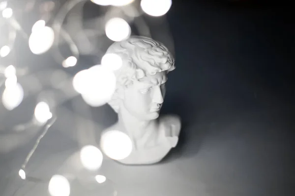 Estatua de yeso de la cabeza de David. Copia de yeso estatua David de Miguel Ángel entre globos de lámina de oro rosa —  Fotos de Stock
