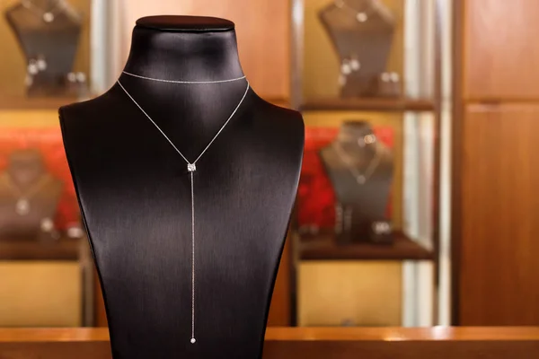 Collar de oro blanco con diamantes en un stand en boutique de joyería de moda. Cuello de pie negro con joyas de lujo, accesorios para mujer en la ventana de la tienda. — Foto de Stock