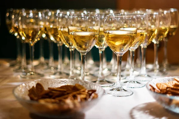 白ワインのグラスは、行に立っている。パーティー、テーマを祝う。バーにはお酒が立ち並んでいます。ワイングラス — ストック写真