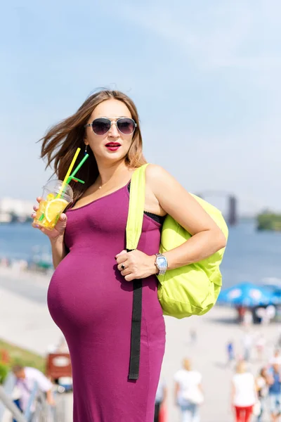 漂亮的年轻孕妇喝着果汁 享受着在城市的堤岸上散步的乐趣 女游客 积极健康的怀孕和生活方式 旅游和出国旅行 — 图库照片