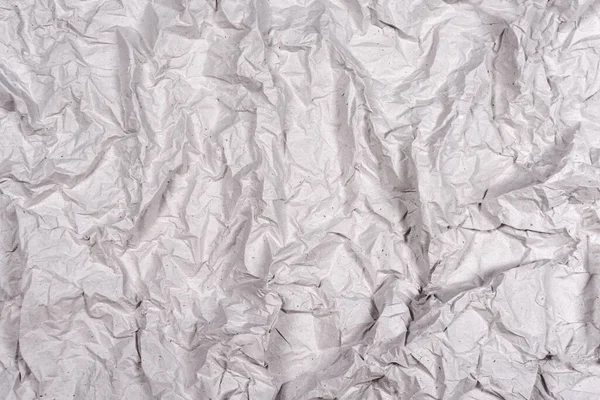 Crumpled gray paper texture. Wrinkled paper background with cracks and kinks.