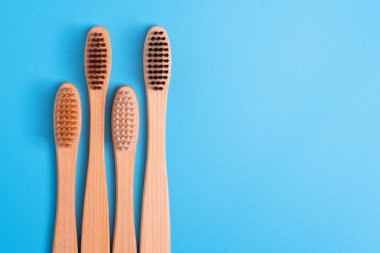 Mavi arka planda bambu diş fırçaları. Çevre dostu günlük ağız temizliği, diş bakımı ve sağlık. Ağız temizleme ürünleri. Diş bakımı konsepti. Metin veya logo için boş yer