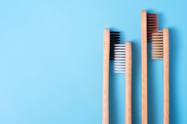 Mavi arka planda bambu diş fırçaları. Çevre dostu günlük ağız temizliği, diş bakımı ve sağlık. Ağız temizleme ürünleri. Diş bakımı konsepti. Metin veya logo için boş yer
