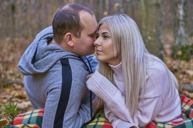 Adam kızın kulağına tatlı sözler fısıldıyor.