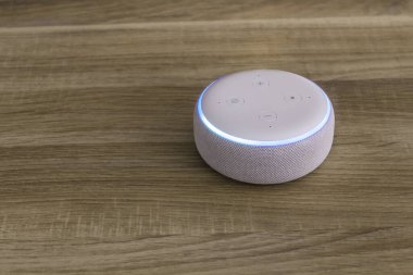 Amazon yankı noktası, ahşap arka planda ses tanıma özelliği olan ses kontrollü hoparlör.