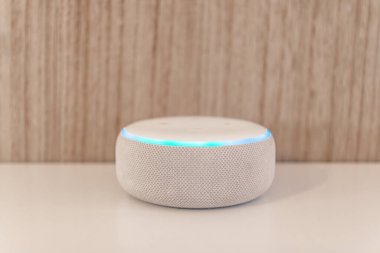 Amazon yankı noktası, ahşap arka planda ses tanıma özelliği olan ses kontrollü hoparlör.