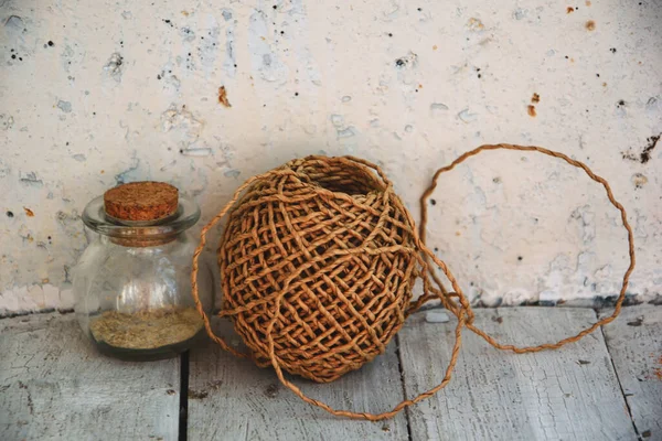 Doğal kozmetik yıkama konsepti için yulaf ezmesi tozu. İçine yulaf ezmesi dökülen beyaz bir havan topu, içine ubtan döküldüğü mantarlı yuvarlak bir cam şişe, bir rulo kağıt ambalaj.