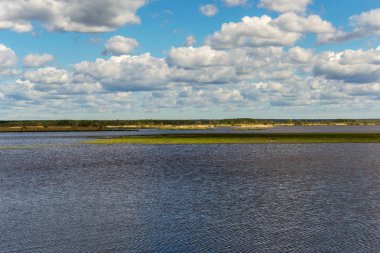 Baharda bulutlarla kaplı geniş göl ve gökyüzü manzarası