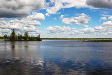 Bulutlu bir günde küçük bir adayla gölün doğal manzarası