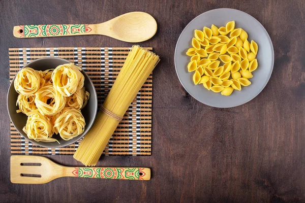 Dry fettuccine pasta in a grey ceramic Cup on a background of ba — Stock Photo, Image