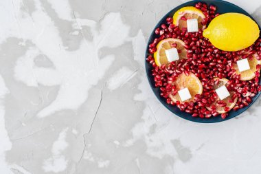white sugar cubes on a background of red pomegranate seeds and y